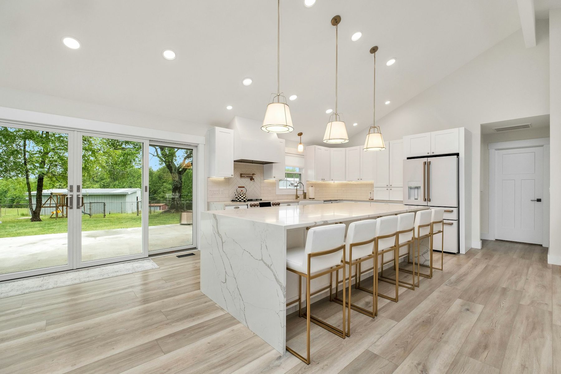 A kitchen with a white veined waterfall island bench
